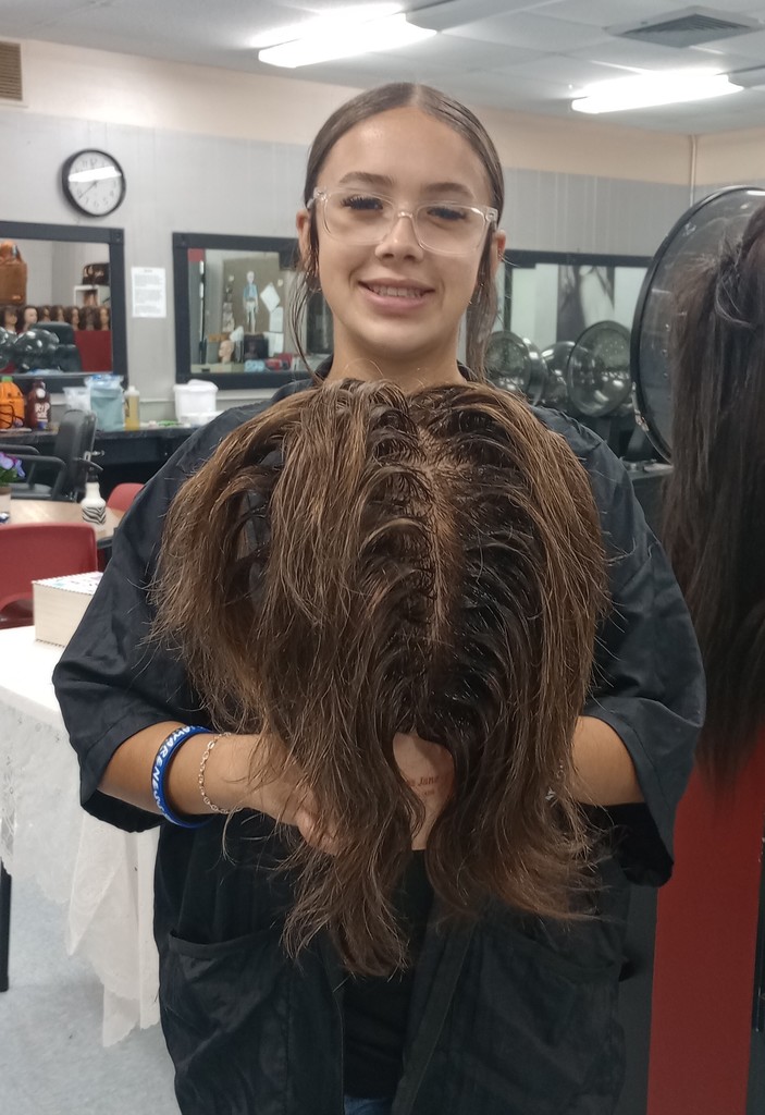 student holding mannequin head  with chemical service