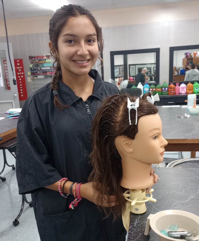 student holding mannequin head  with chemical service