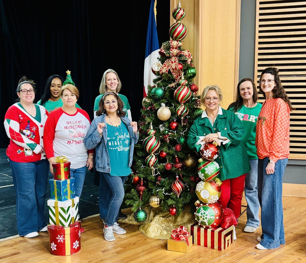 staff around tree in holiday shirts