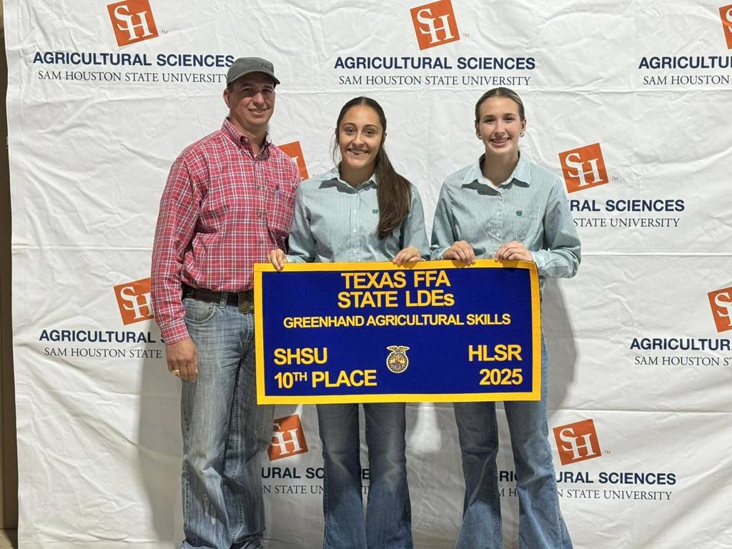 2 girls and mr. wilson holding their FFA banner