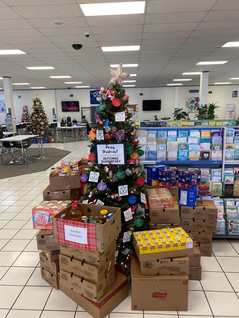 tree surrounded by stacks of boxes filled with canned goods