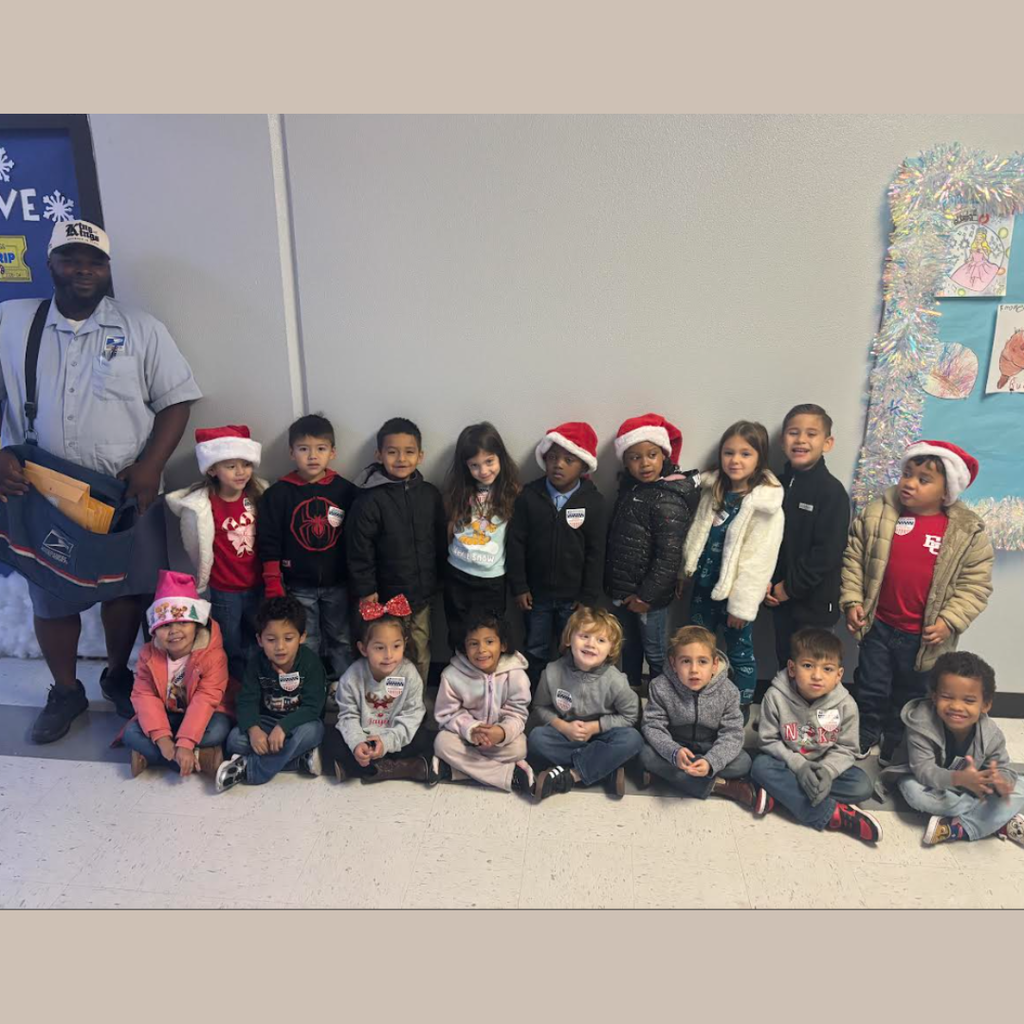 mailman standing with class of kids in hallway