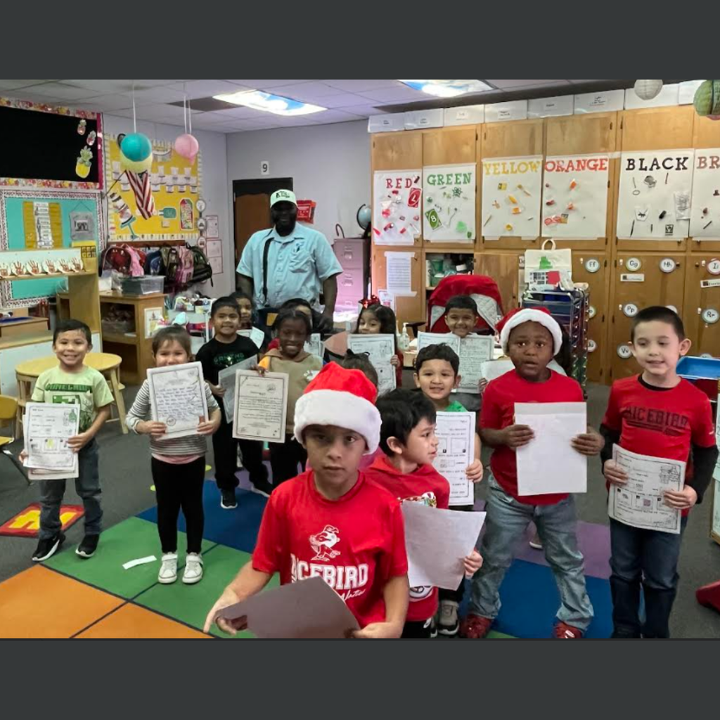 kids holding their letter and posing for picture with greg