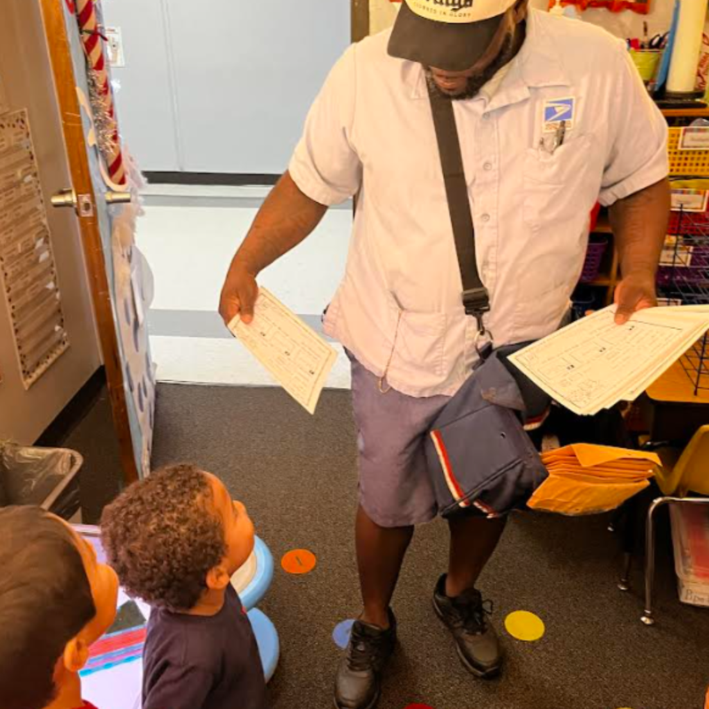mailman handing small child a piece of paper