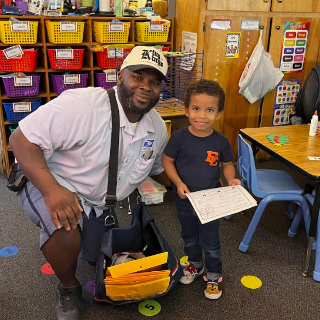 mailman posing with small child