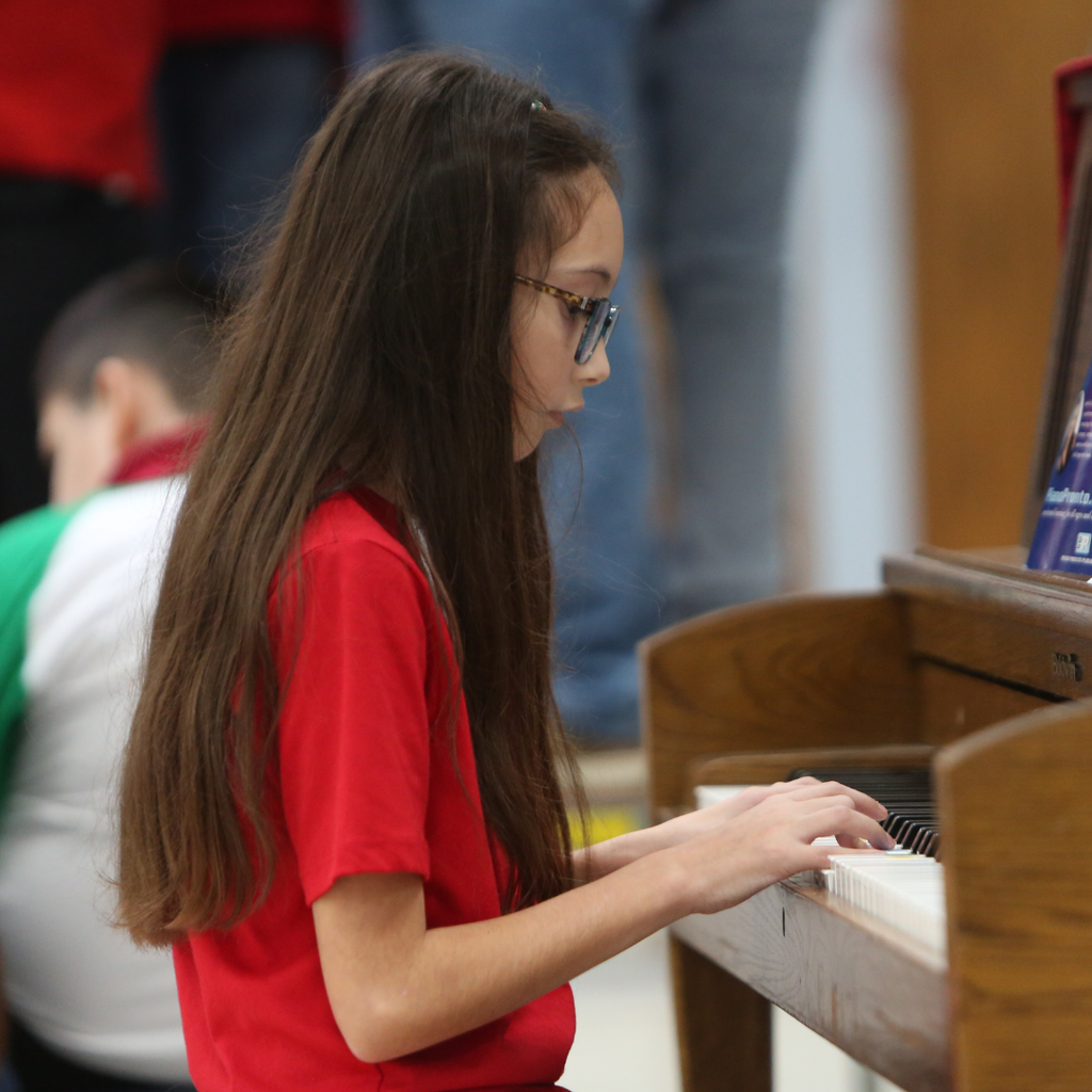 girl playing the piano at program