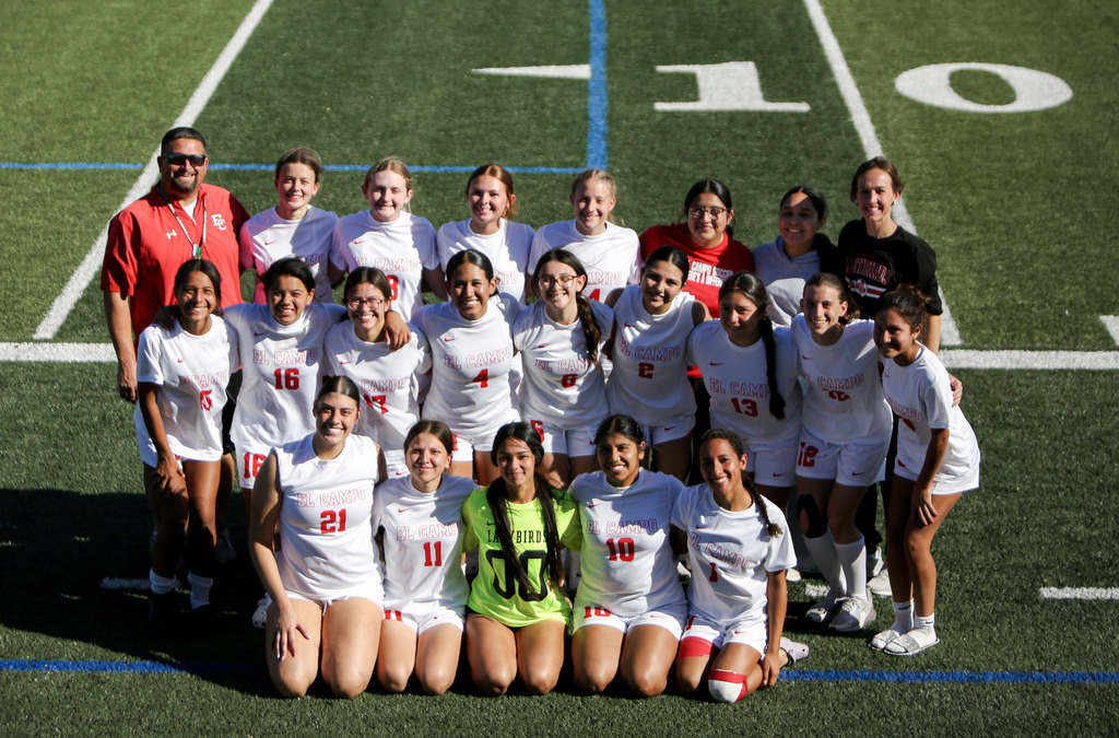 ladybird soccer team and coaches posed on soccer field