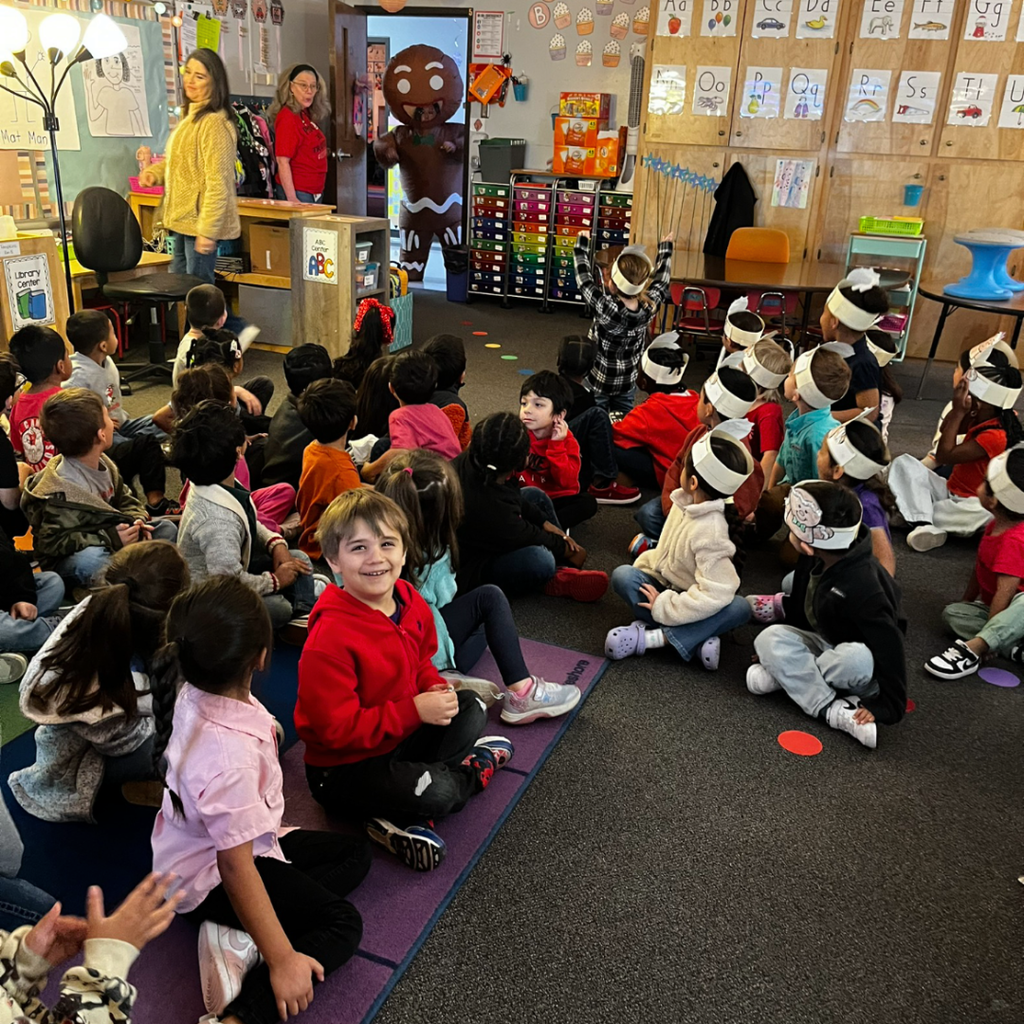 kids on carpet looking at a ginger bread man