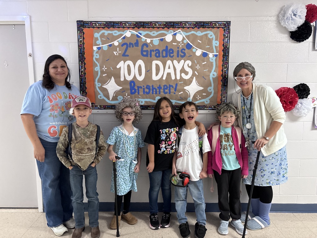 kids and teachers dressed as old people or in 100 day shirts by sign reading "2nd grade is 100 days brighter!"