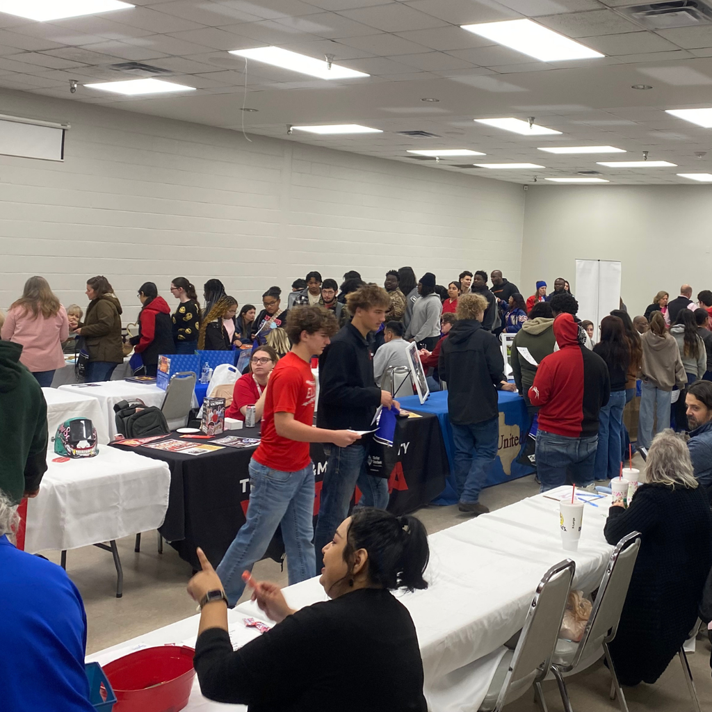 students talking to vendors around a room