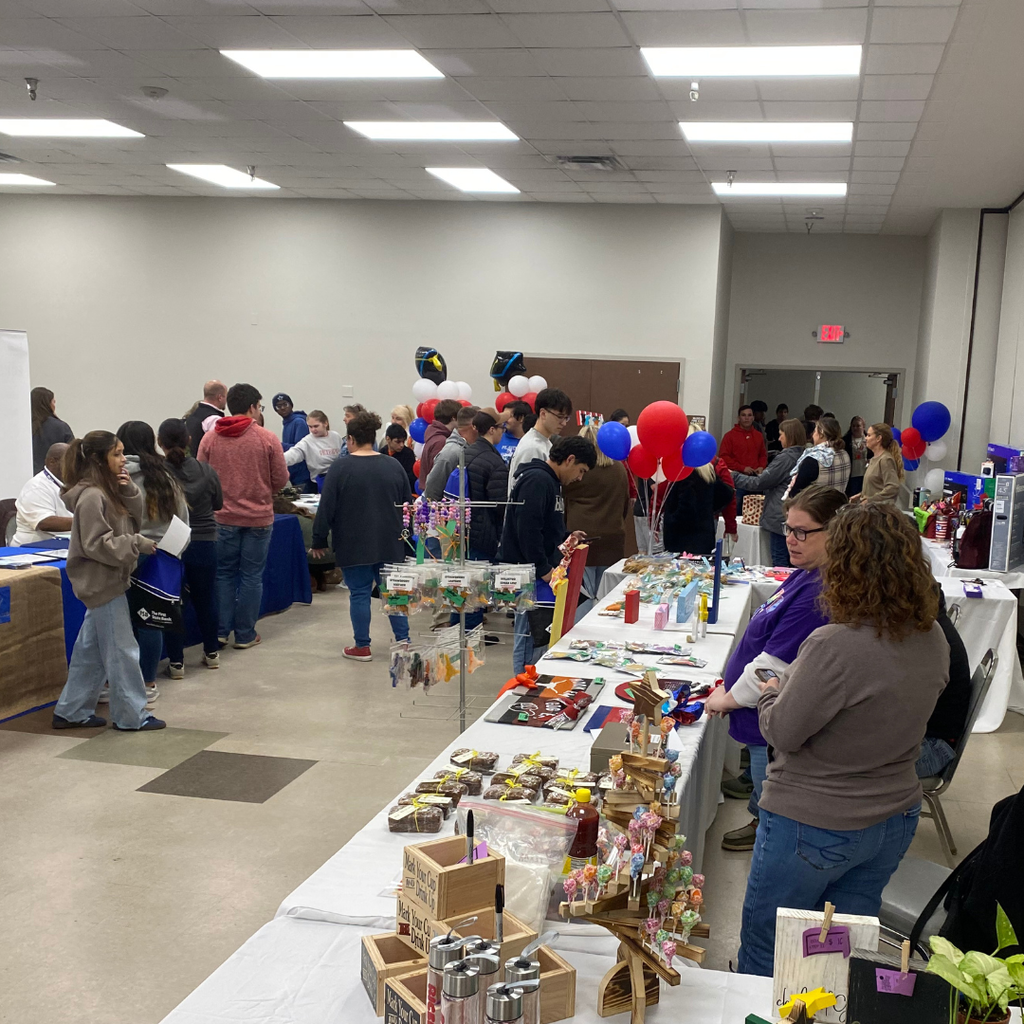 students talking to vendors around a room
