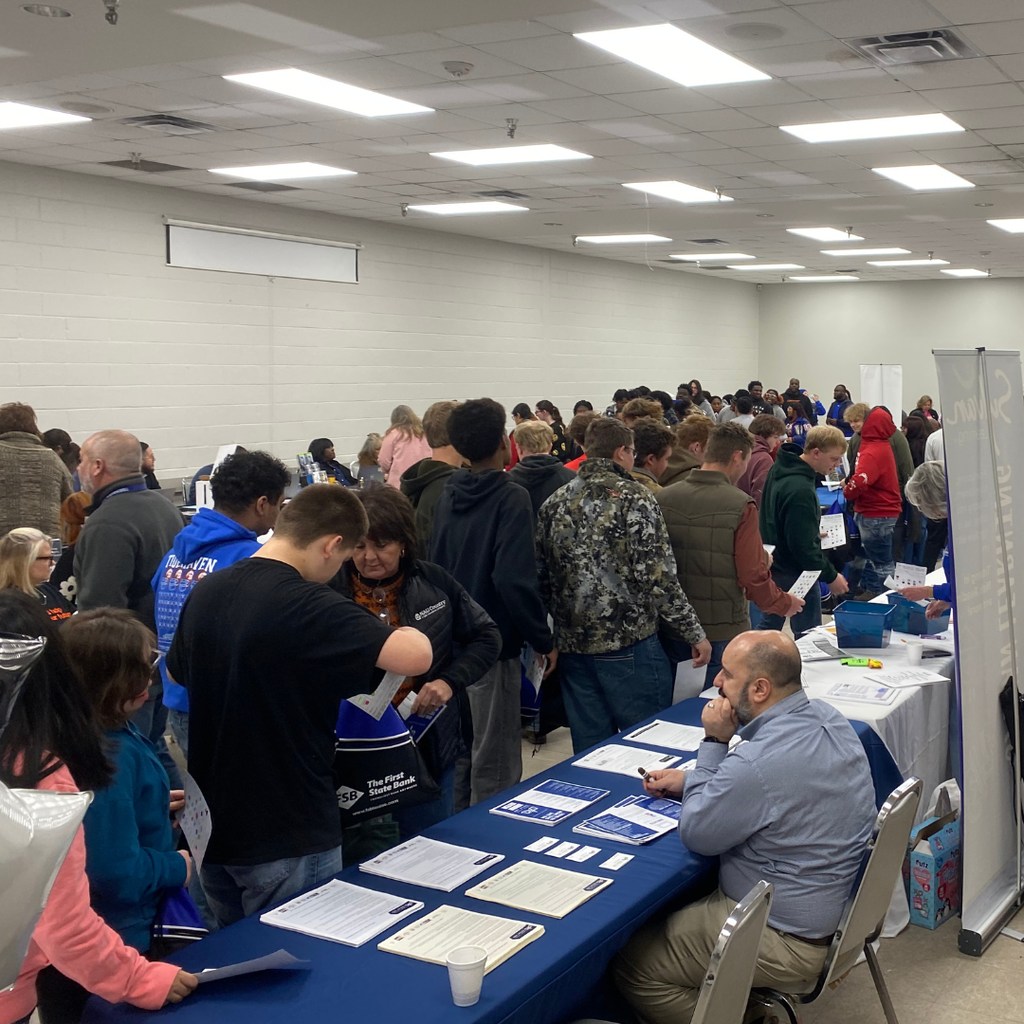 students talking to vendors around a room