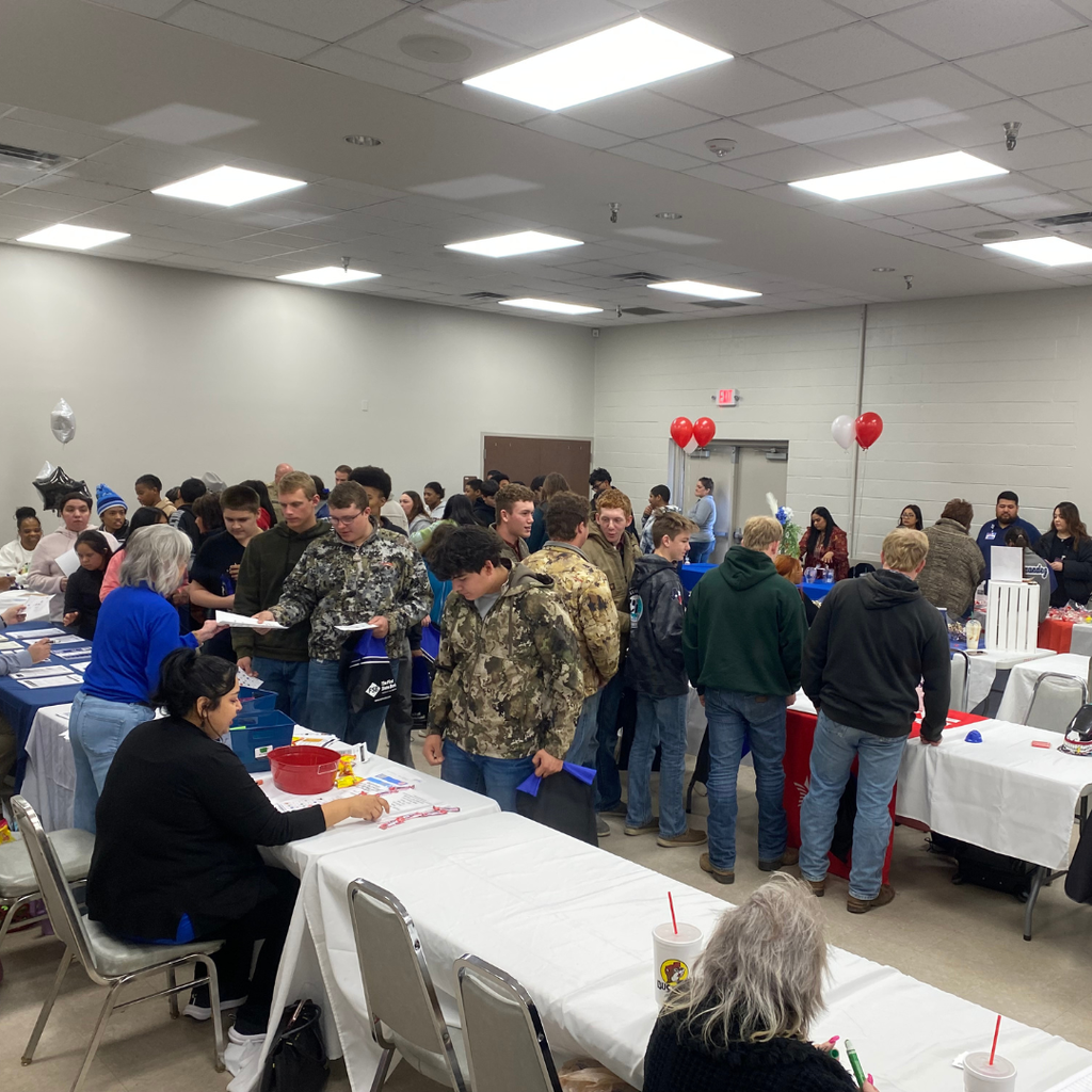 students talking to vendors around a room