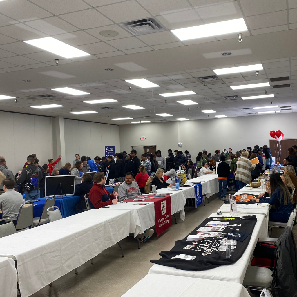 students talking to vendors around a room