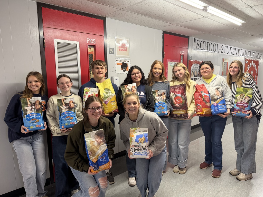 group of students holding bags of dog food