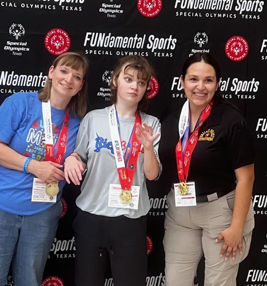 Summer wearing gold medal alongside her mom and volunteer at event