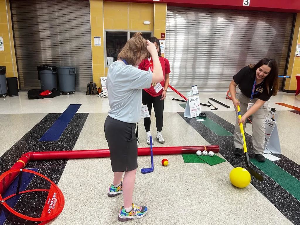 Summer performing skill with a club and large ball