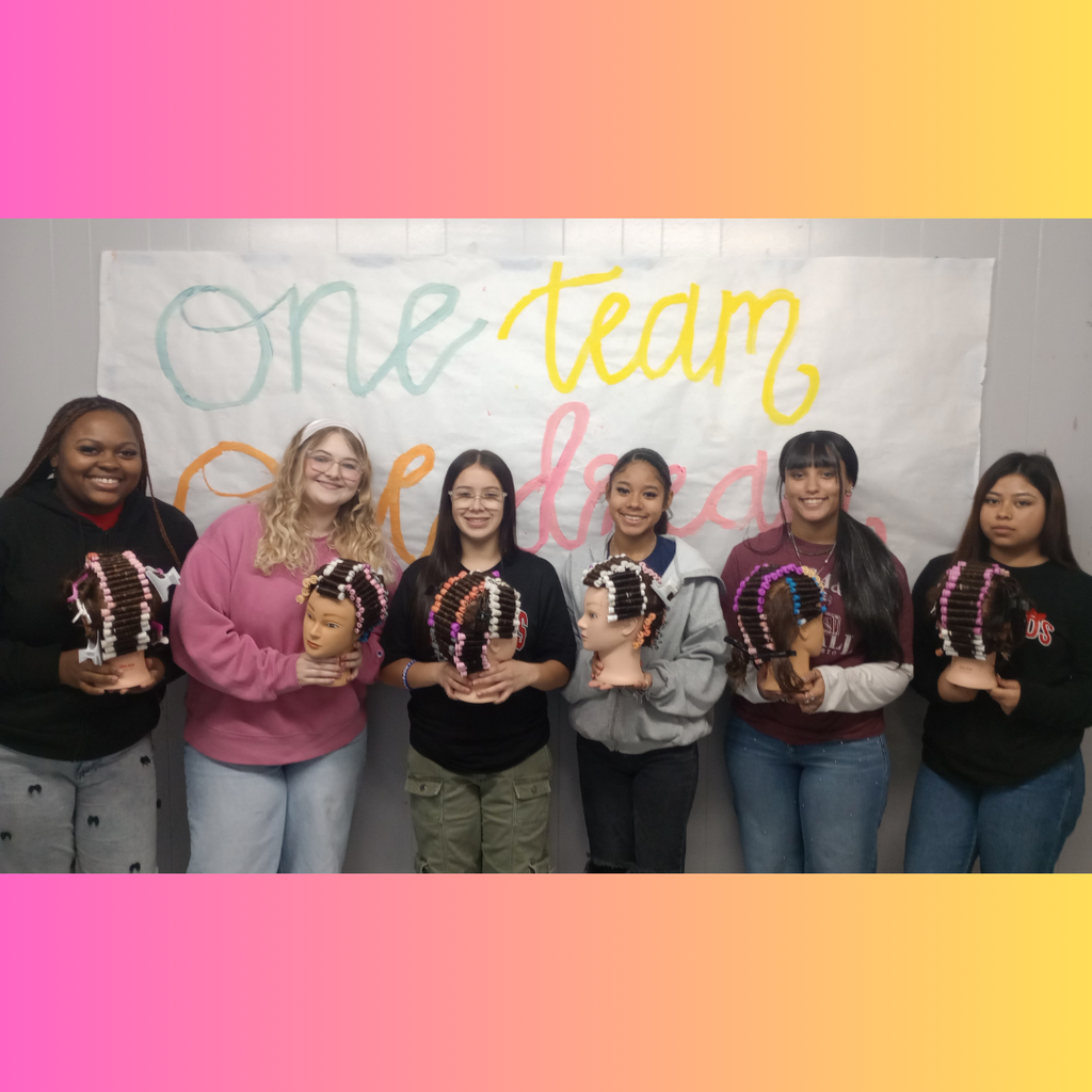 6 girls proudly holding a mannequin head featuring a completed permanent wave hair-rolling technique