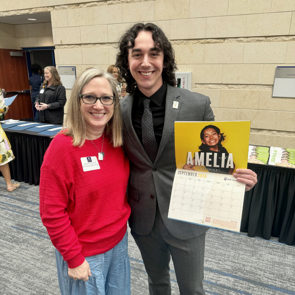 Lyford posing with man in suit holding a calendar showing the september "amelia" at the blood bank luncheon