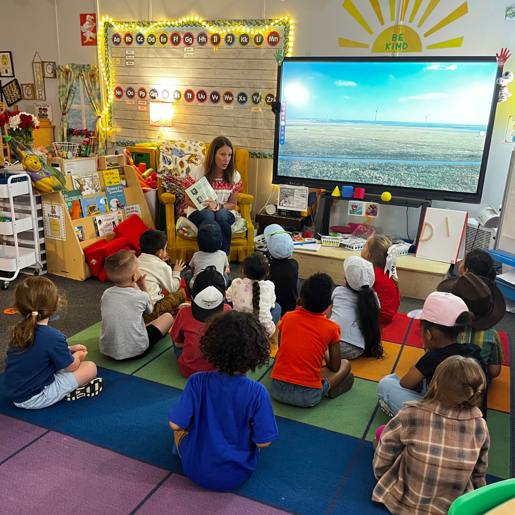 adult woman reading to students in classroom