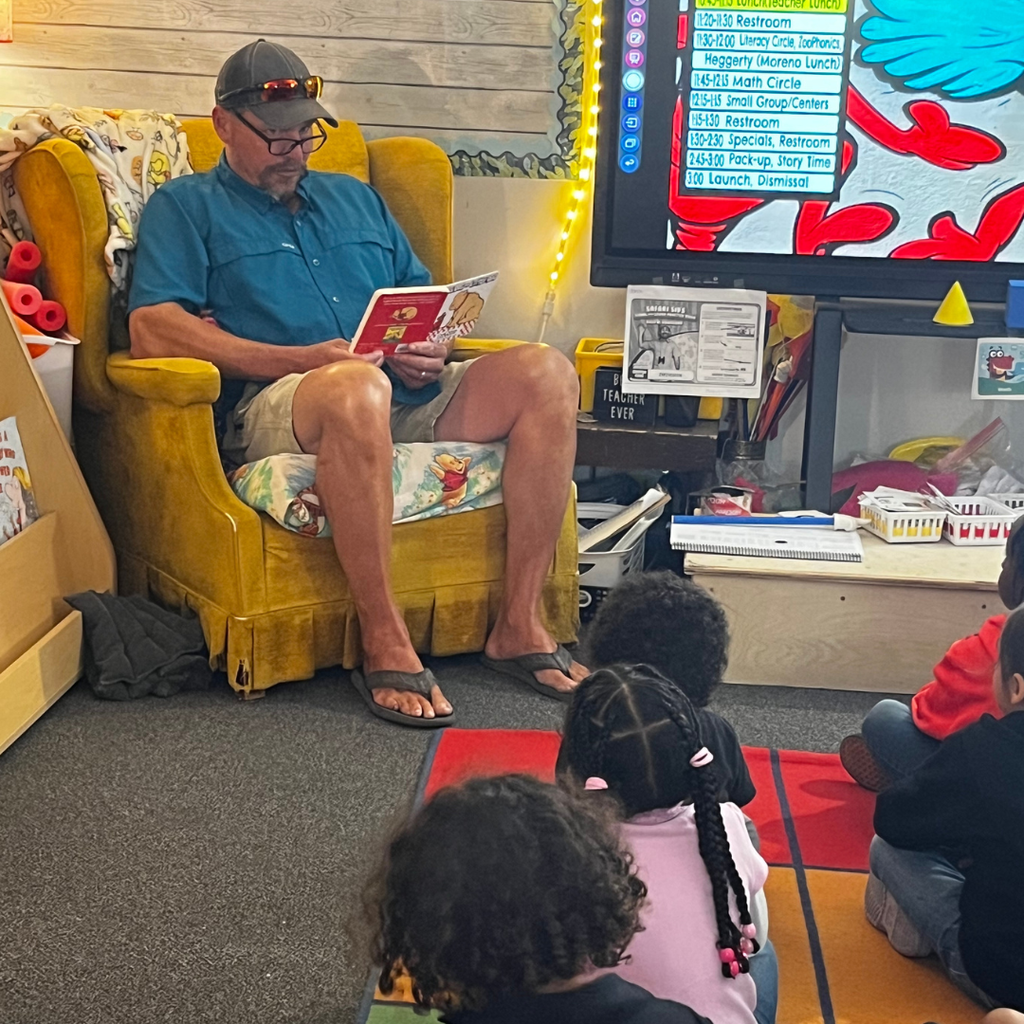 adult male reading to students in classroom