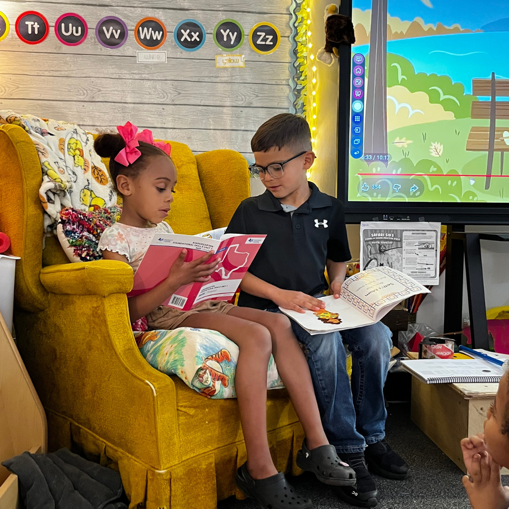 2 small students reading to students in classroom