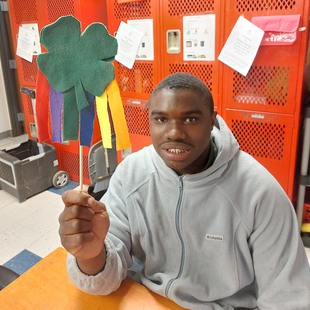 a student showing off his clover wand with colorful streamers hanging