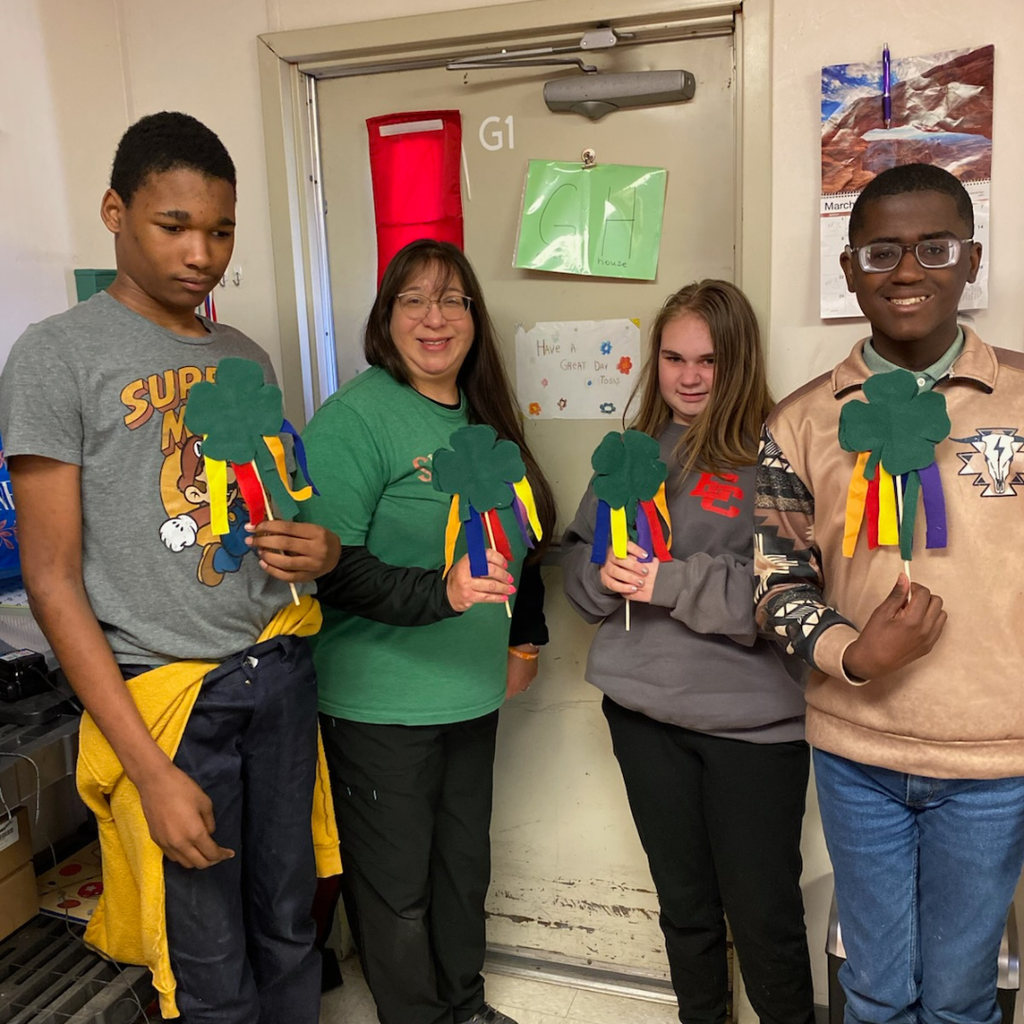 teacher and 3 students showing off their wands