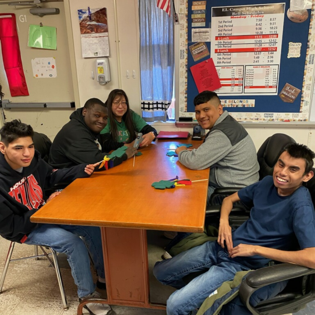 table of 5 people smiling with their wands