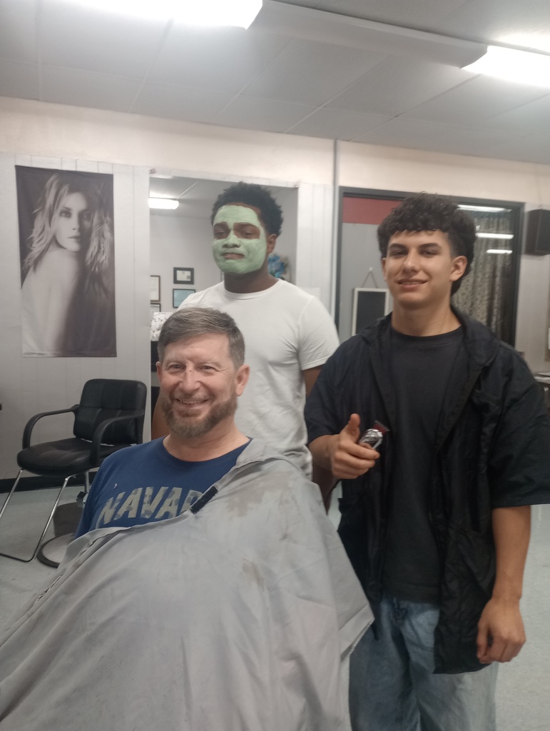 Jackson posing with Mr. Larson after a haircut, while BJ stands behind them wearing a green face mask
