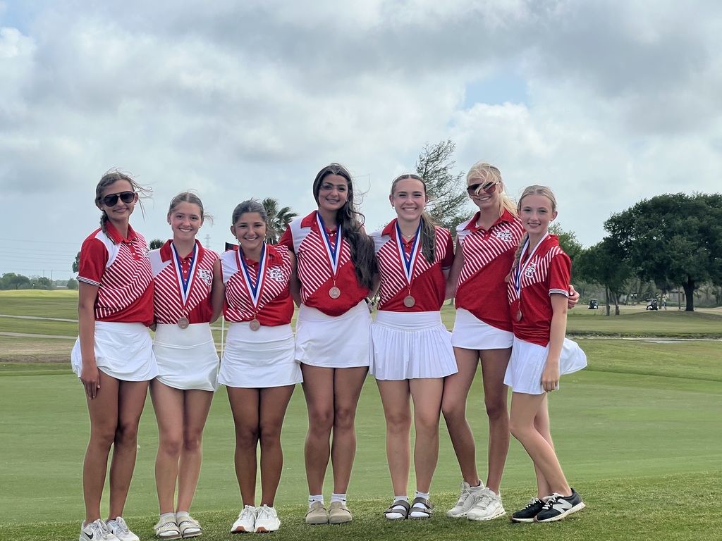 girls golf team in uniform on the course with 5 of the 5 of the 7 wearing 3rd place medals