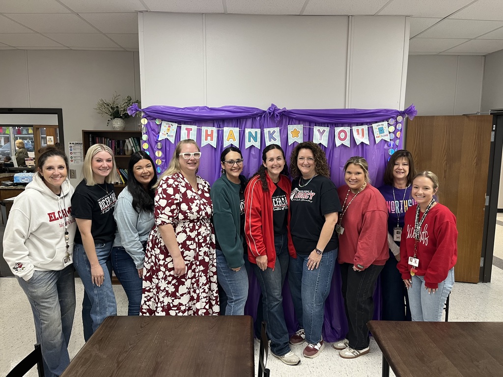 A group of ten smiling female staff members posing together in front of a "Thank You" banner during a celebratory breakfast at Northside.