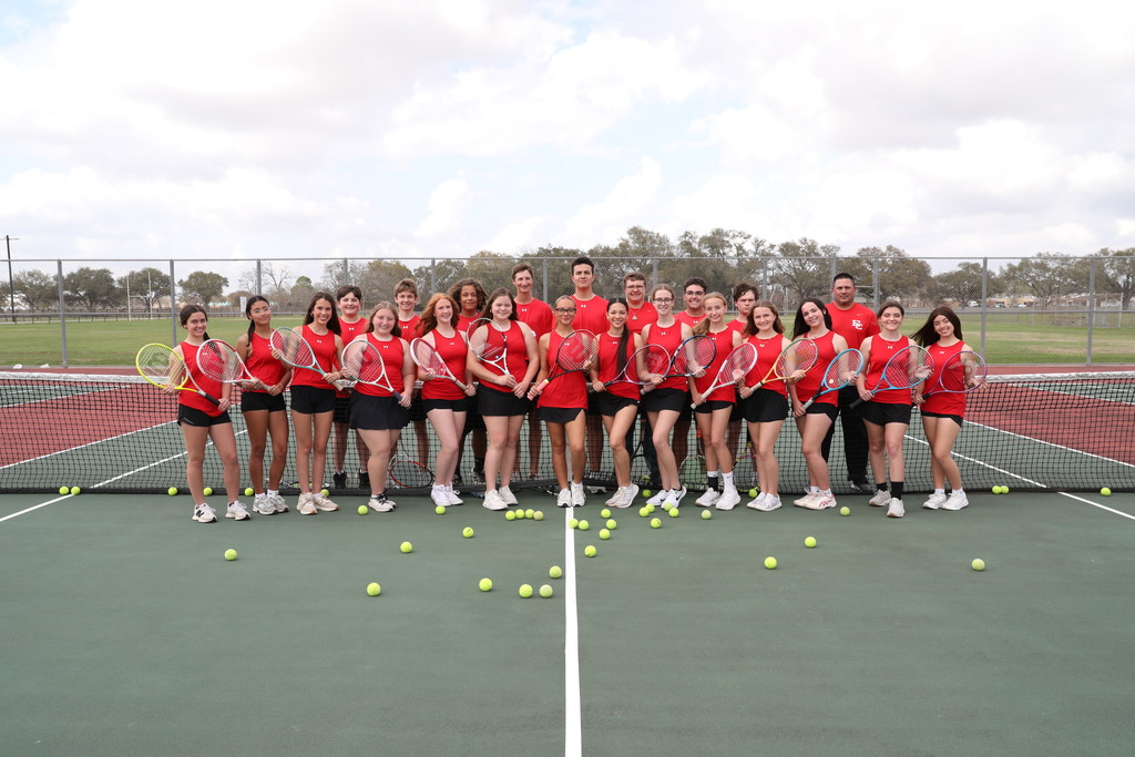 official tennis team picture on the court holding rackets with tennis balls spread all over the court