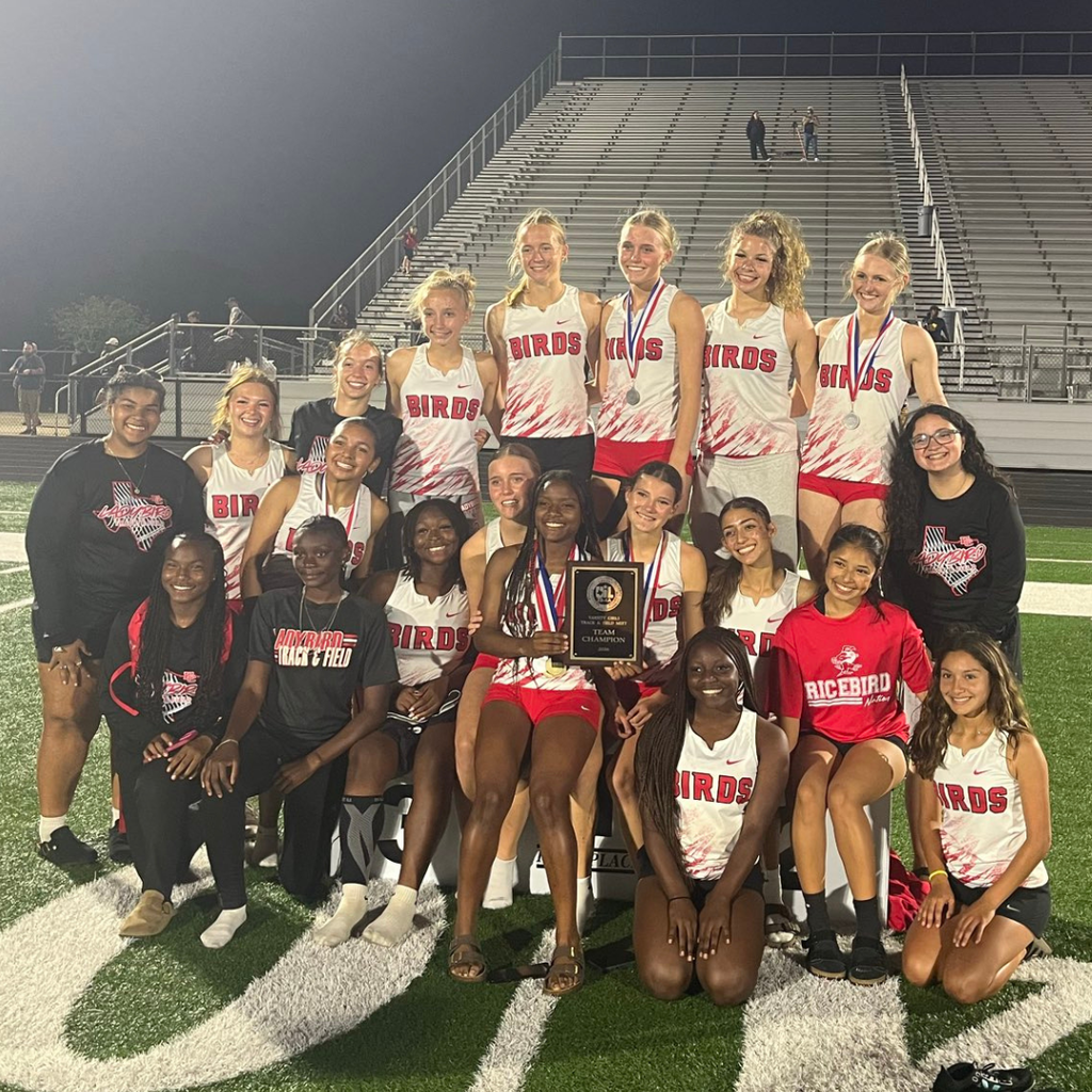 girls track team with medals and plaque