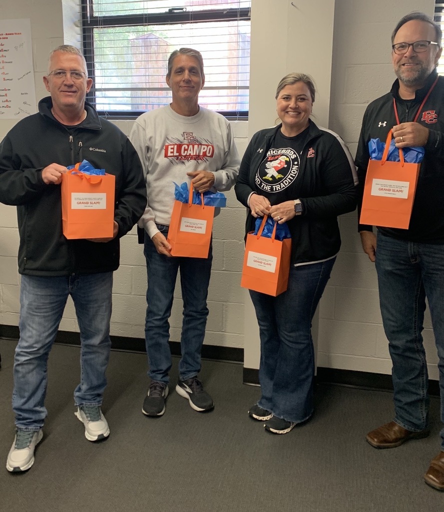 4 adults holding gift bags