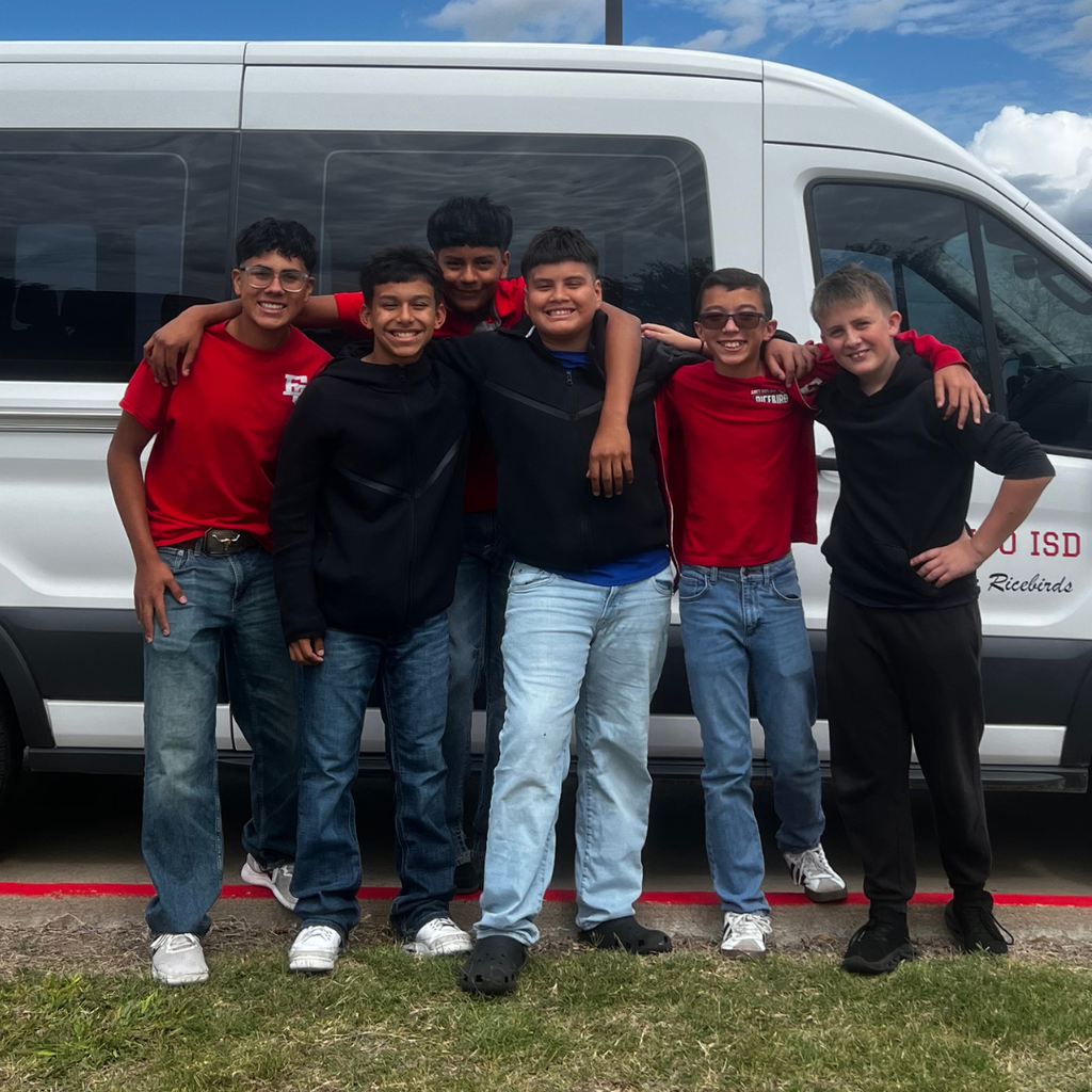6 boys standing in front of a school van
