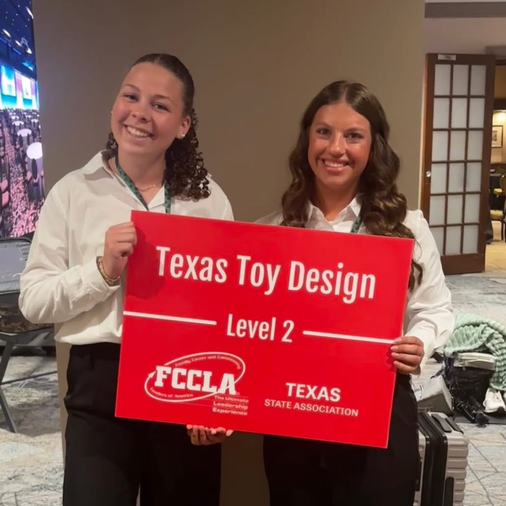 riha and mendel hold a red sign that reads "Texas Toy Design Level 3" with the FCCLA Texas State Association logo.