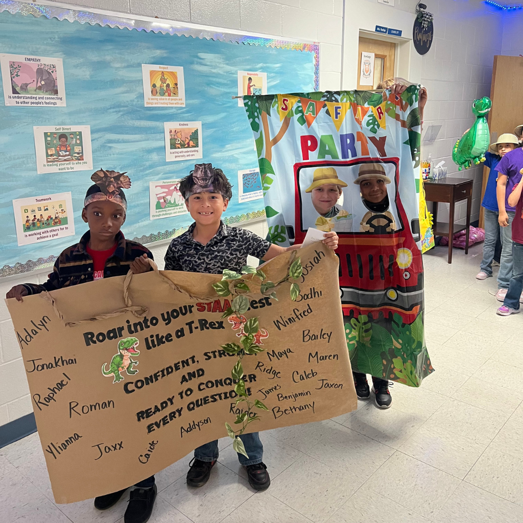 Students posing with a "Roar into your STAAR" dinosaur poster featuring encouraging messages and names.