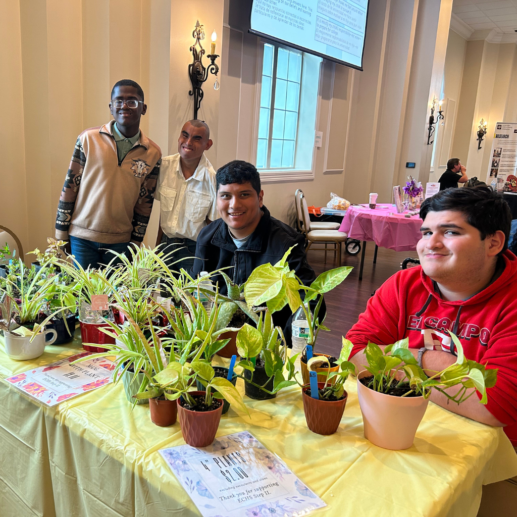 4 boys at a table selling plants