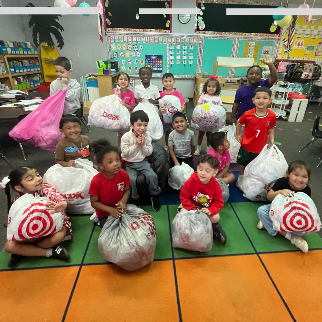 several excited kids on carpet holding bags of plastic grocery bags