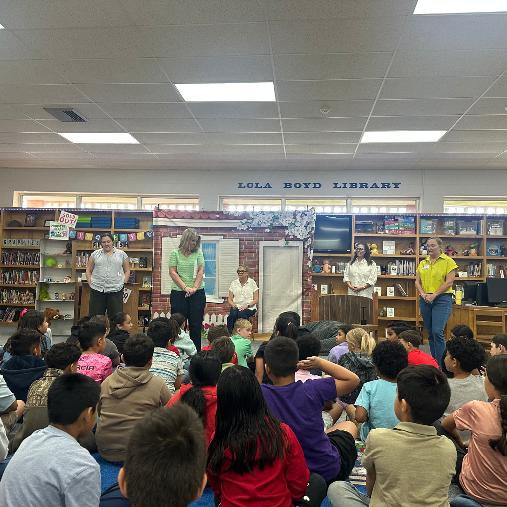 5 ladies answering questions from the students seated on the floor in the library
