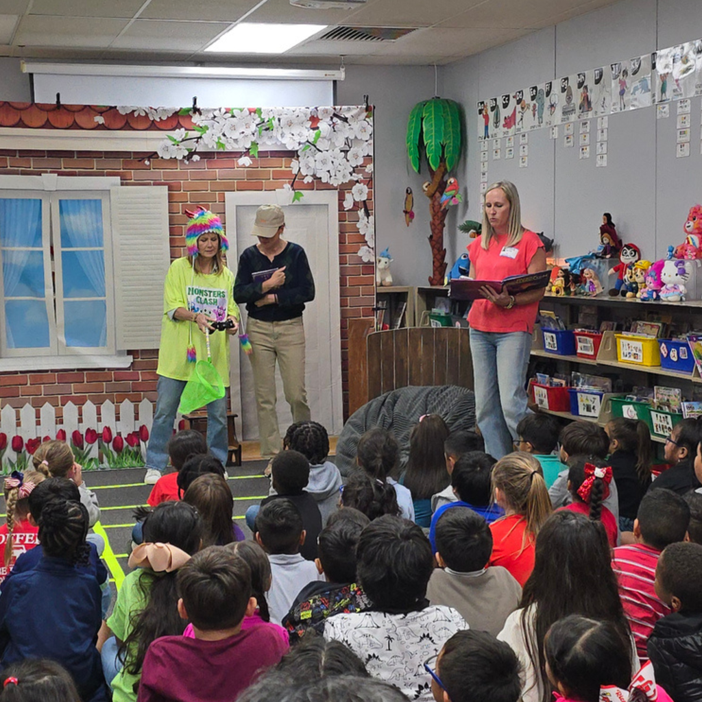 Members of the Sesame Club engage with Myatt students during a Reading Is Fundamental (RIF) book party in a decorated library setting.