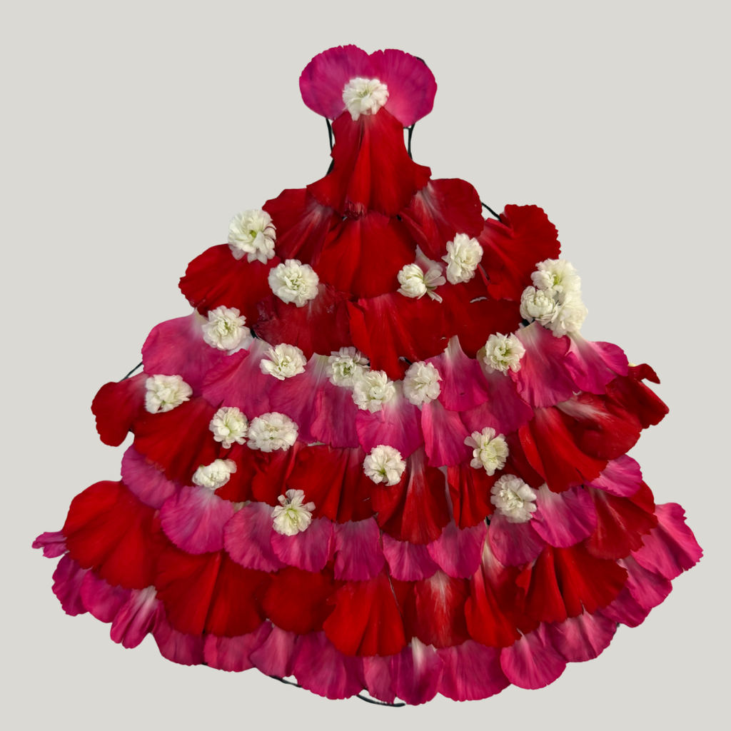 a dress made from red and pink flower petals, accented with small white flowers arranged in rows across the skirt.