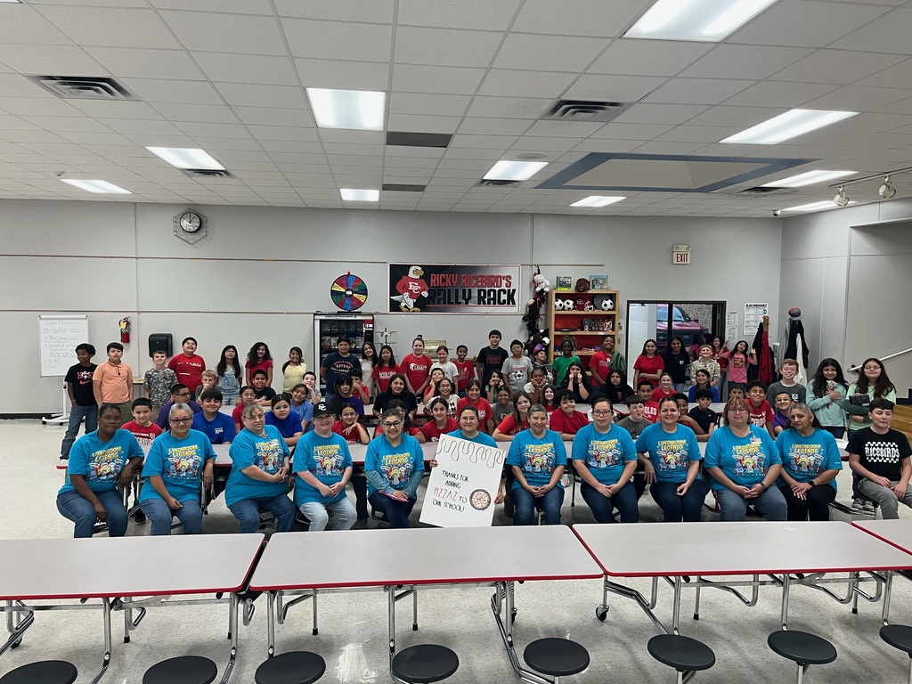A large group of students and staff posing together in the Northside Elementary cafeteria. In the front row, the food service team wears matching blue "Lunchroom Legends" shirts and holds a thank-you sign. Behind them, dozens of students are gathered to celebrate School Lunch Heroes Day.