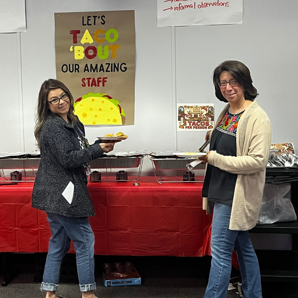 2 ladies at the taco bar smiling while making their plates