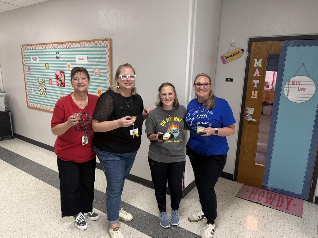 Northside Elementary staff members smiling and holding up small containers of decorative treats and cookies.