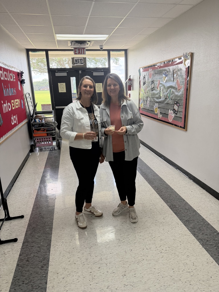 A school hallway decorated with colorful paper lanterns and "Teacher Appreciation" banners, with staff members posing with their treats.ound.