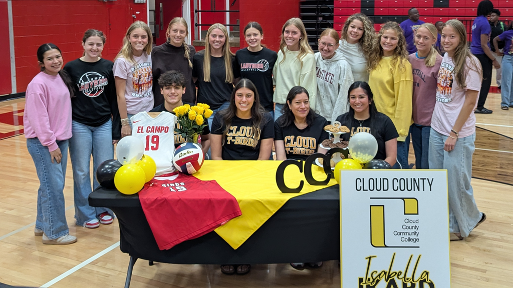 ikard at decorated table surrounded by girls from the volleyball team
