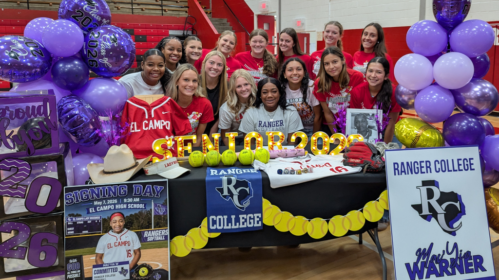 warner at decorated table surrounded by girls from the softball team