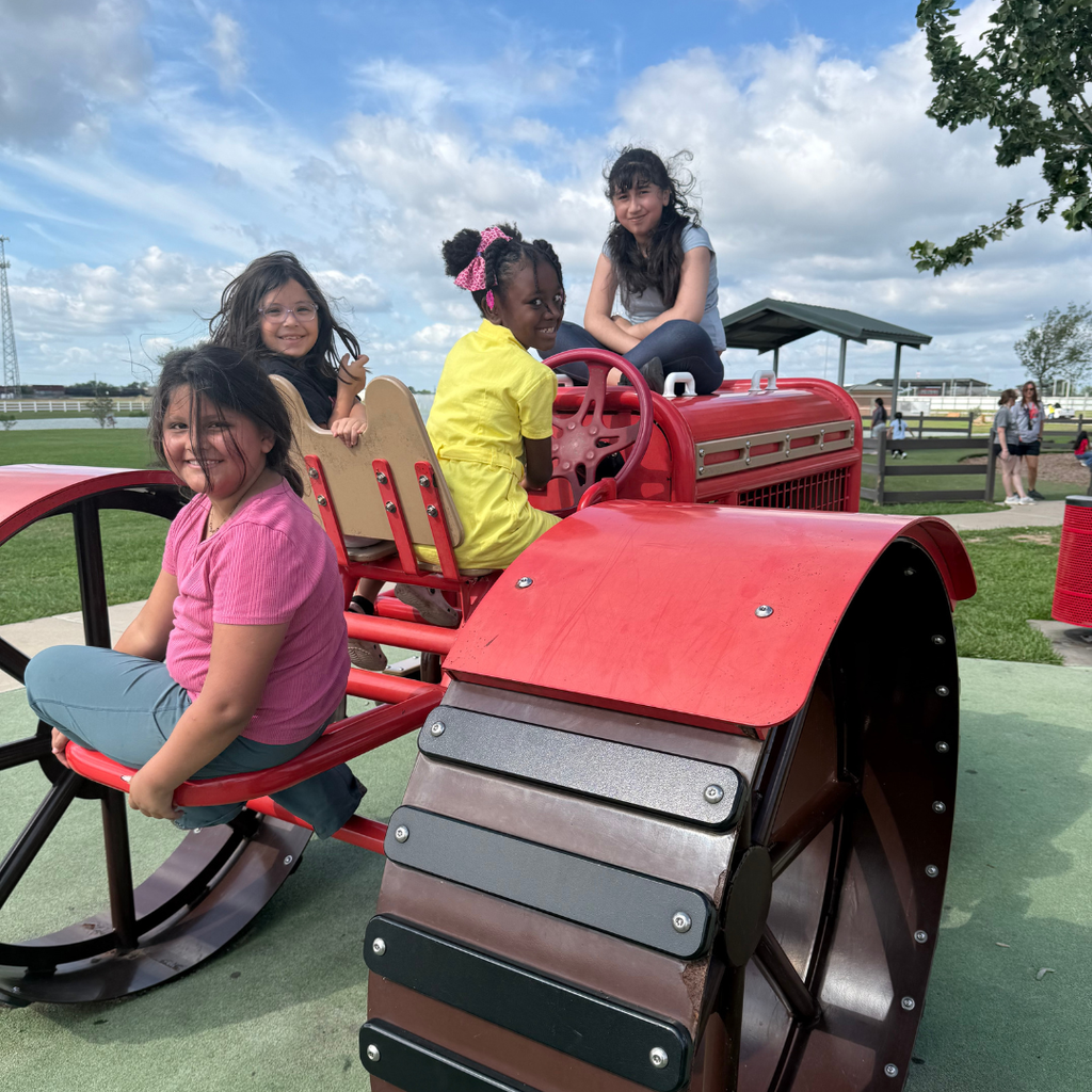 4 kids on the red tractor at the park